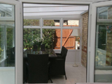 Open doors to a white uPVC lean to conservatory