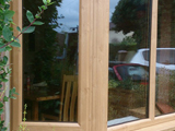Exterior view of triple pencil ogee profile uPVC double glazed bay window in light oak